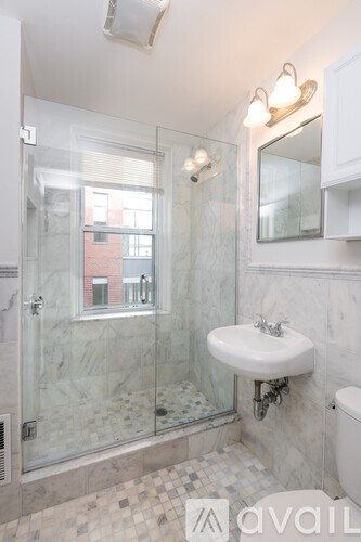 A bathroom with a marble sink and shower.