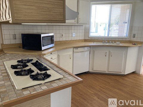 A kitchen with a black microwave on the counter.