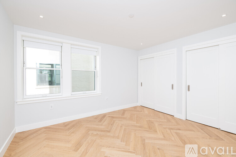 A room with a window and wooden flooring.