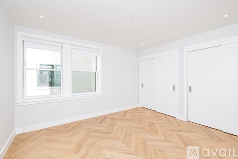 A room with a window and wooden flooring.