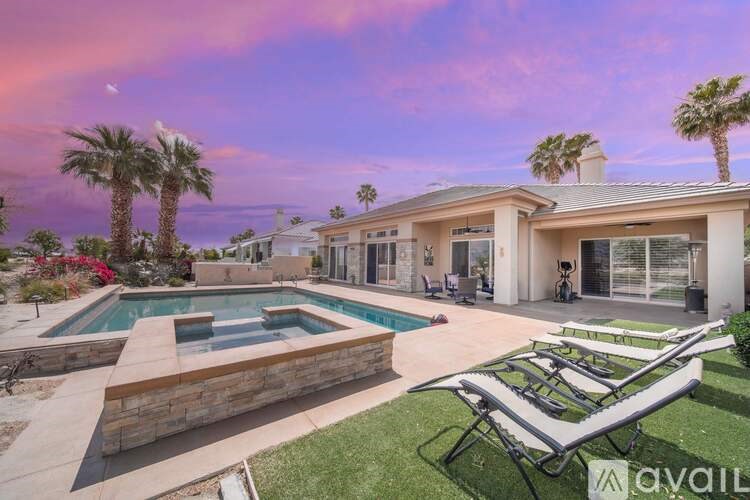 A house with a pool and a lawn chair in front of it.