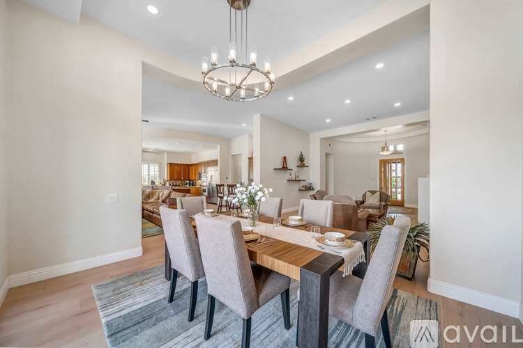 A dining room with a wooden table and grey chairs.