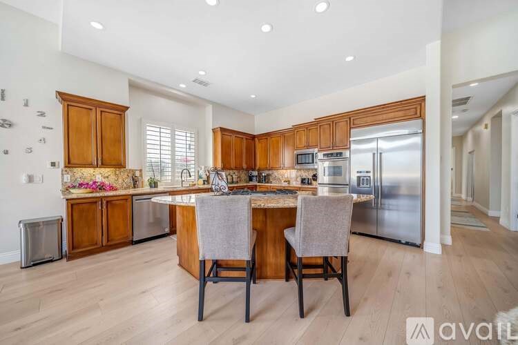 A kitchen with wooden cabinets and a center island with a marble top.