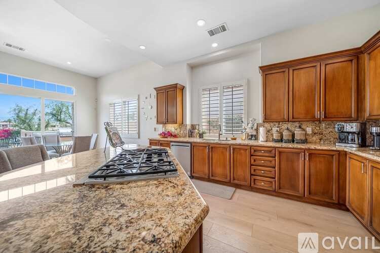 A kitchen with granite countertops and wooden cabinets.