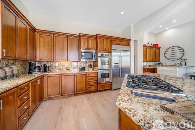 A kitchen with wooden cabinets and a granite countertop.
