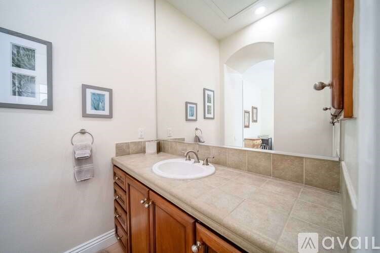 A bathroom with a sink, mirror, and cabinets.