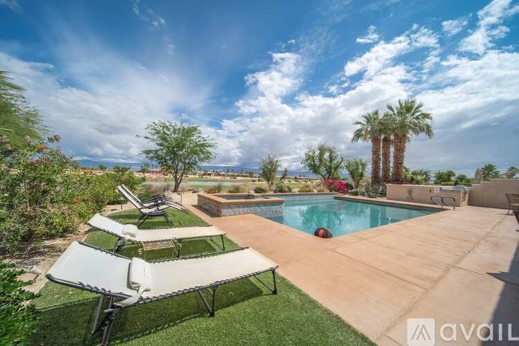 A sunny backyard with a pool and a patio table.