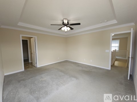 A spacious room with a ceiling fan and two doors.