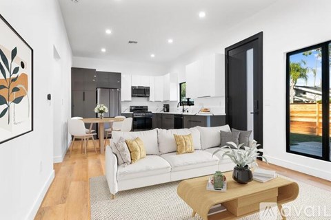 A modern living room with a white sofa and a wooden coffee table.