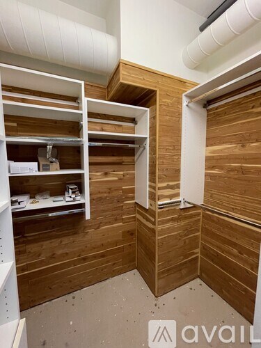 A room with wooden walls and white shelving units.