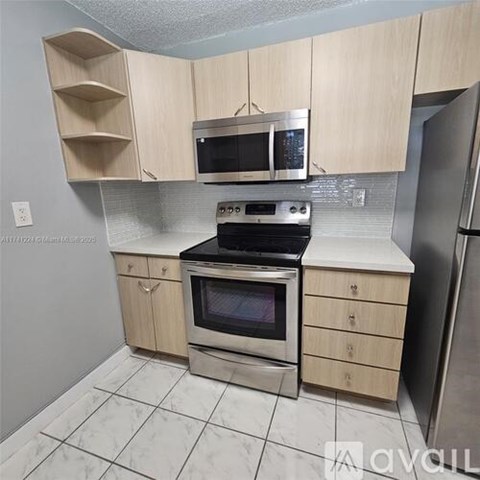 A kitchen with a stove, oven, microwave, and refrigerator.