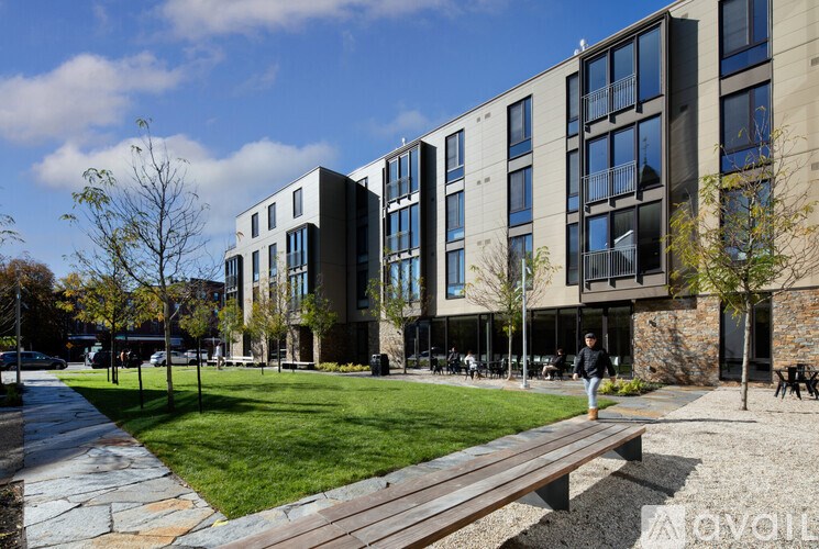A modern building with a grassy area in front.