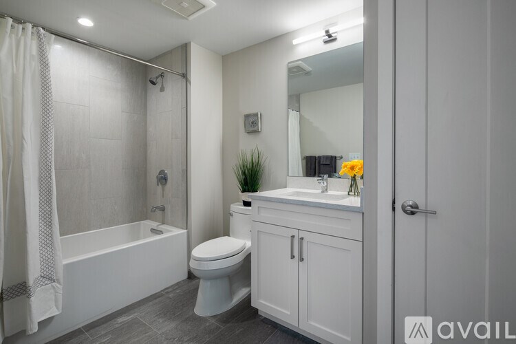 A bathroom with a white toilet, sink, and bathtub.