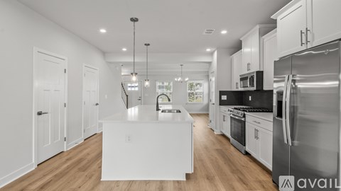 A modern kitchen with stainless steel appliances and wooden floors.