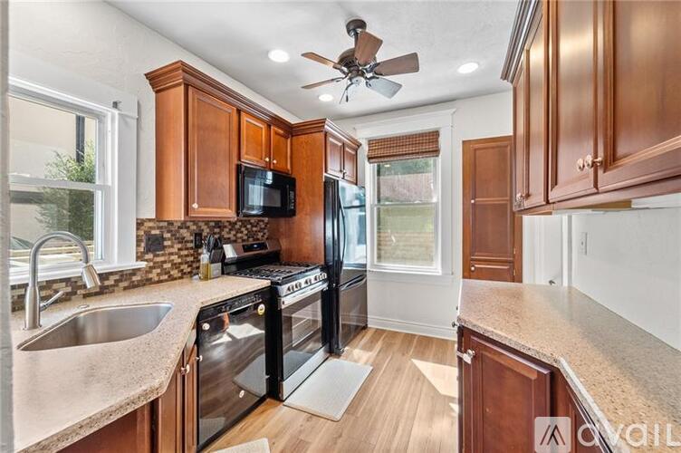 A kitchen with wooden cabinets and a black fridge.