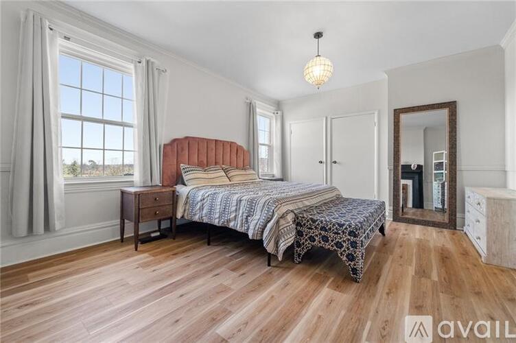 A bedroom with a large bed and wooden floors.