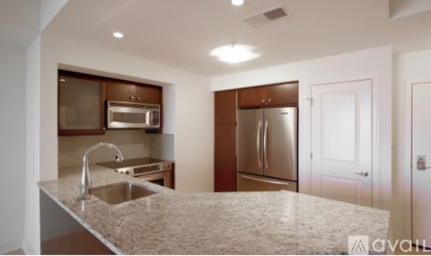 A kitchen with a granite countertop and stainless steel appliances.