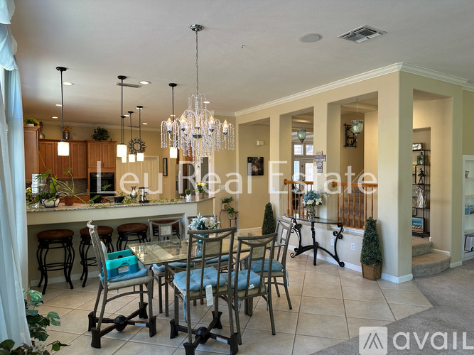 A dining room with a table set for four and a chandelier hanging from the ceiling.