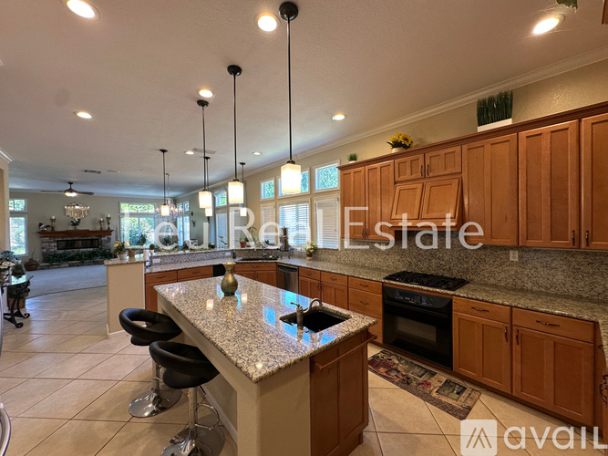 A kitchen with a granite countertop and wooden cabinets.