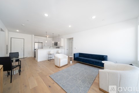 A living room with a blue couch and a white rug.