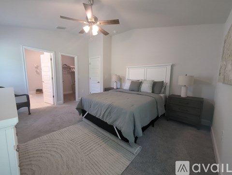 A bedroom with a bed, dresser, and ceiling fan.