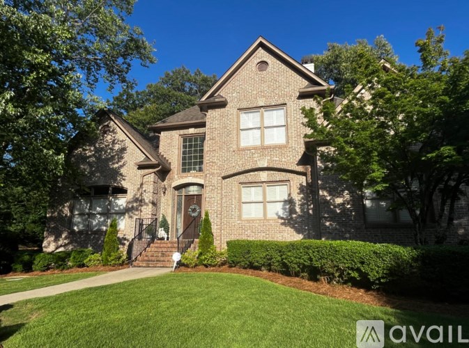 A house with a well-manicured lawn and trees in the background.