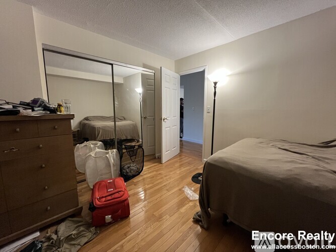 A bedroom with a bed, a dresser, and a mirror.