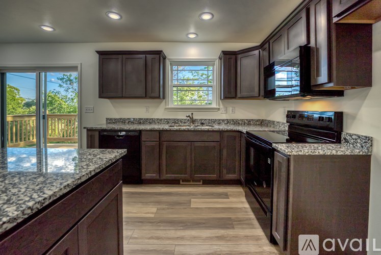 A kitchen with brown cabinets and granite countertops.