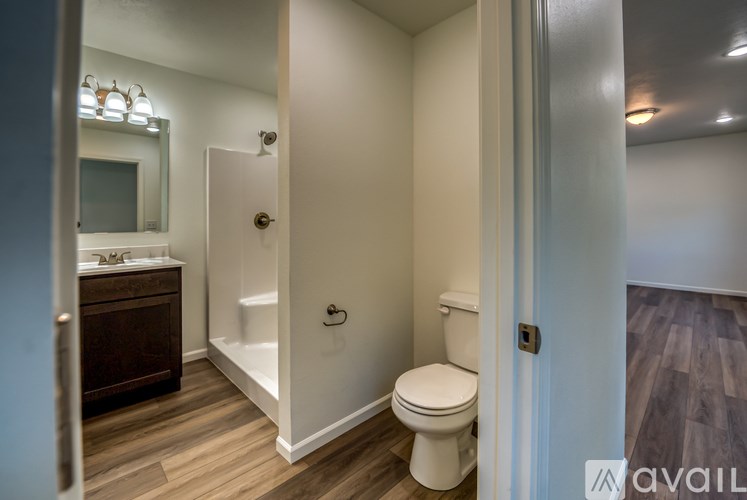 A bathroom with a toilet, sink, and mirror.