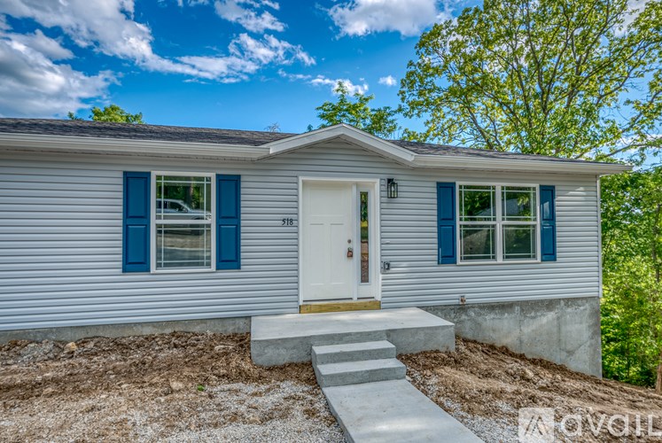 A house with a white door and blue shutters is shown.