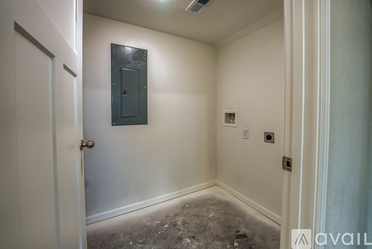 A room with a door and a wall-mounted electrical panel.