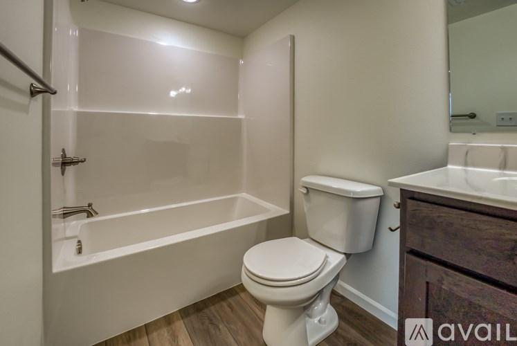 A white toilet sits next to a bathtub in a bathroom.