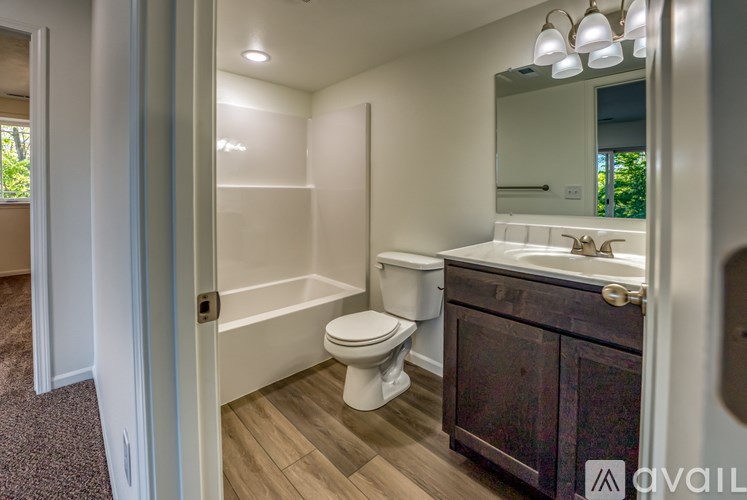 A bathroom with a toilet, sink, and mirror.