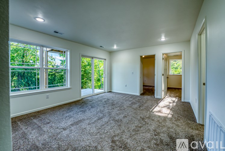 A spacious room with carpeted floor and large windows.