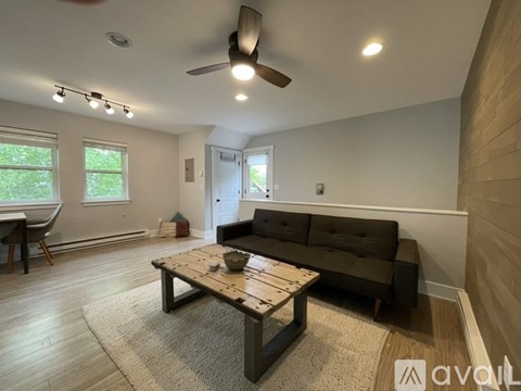 A living room with a wooden coffee table and a brown couch.