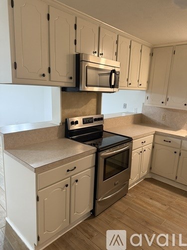 A kitchen with white cabinets and a black stove top oven.