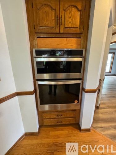 A kitchen with wooden cabinets and a stainless steel oven.