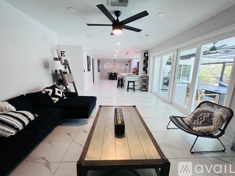 A living room with a black couch and a wooden table.