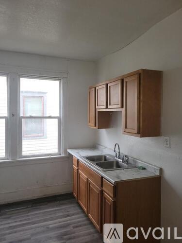 A kitchen with a refrigerator, oven, and sink.
