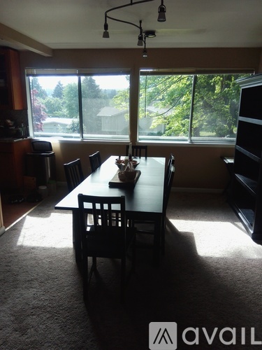 A dining room with a table and chairs.