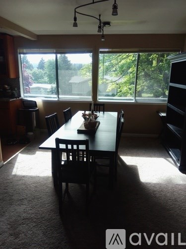A dining room with a table and chairs.