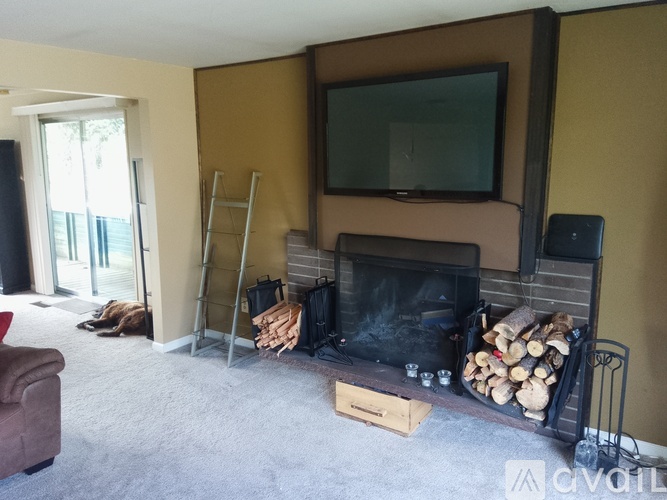 A living room with a fireplace and a television mounted above it.