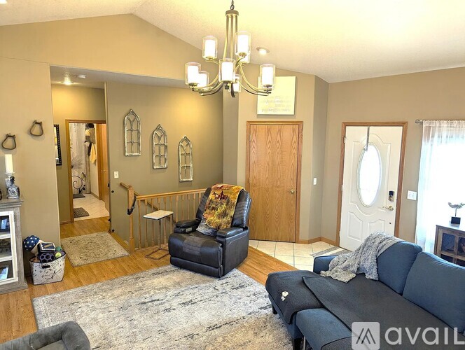 A living room with a black leather chair and a grey sofa.