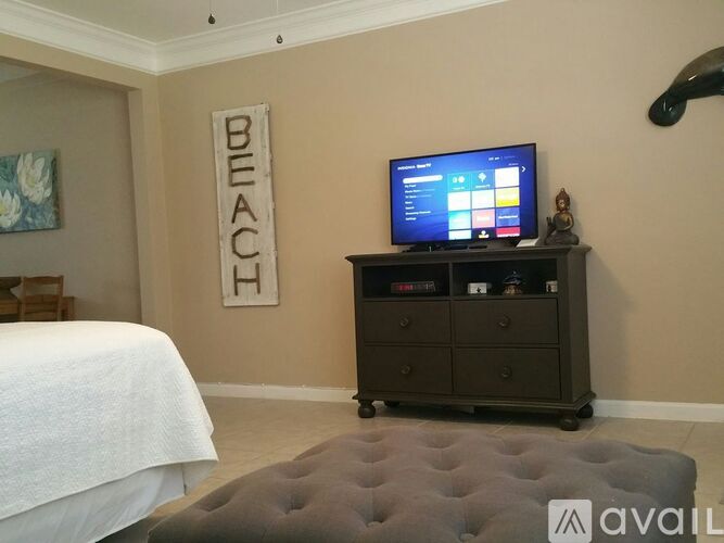 A bedroom with a bed, a dresser, and a sign that says "BEACH".