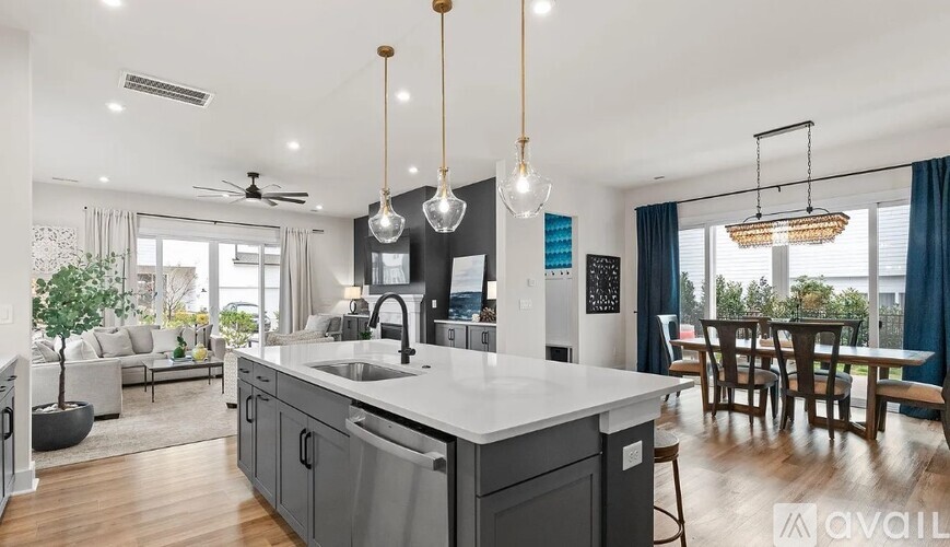 A modern kitchen with a large island and pendant lights.