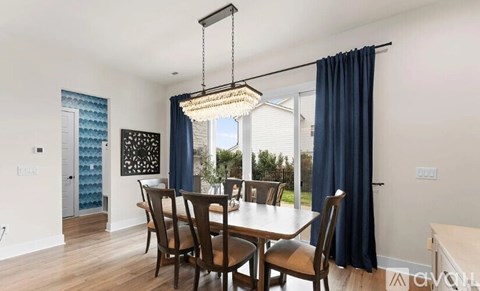 A dining room with a table and chairs.