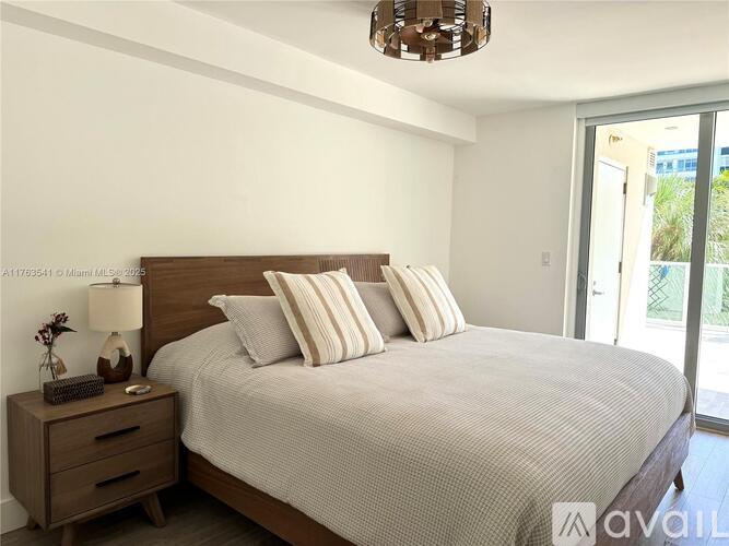 A bedroom with a large bed and a chandelier.
