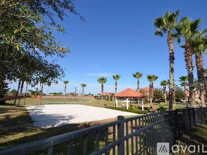 A sunny day at the park with palm trees and a playground.