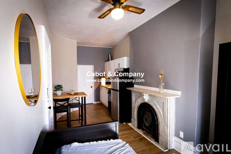 A bedroom with a bed, a fireplace, and a mirror.