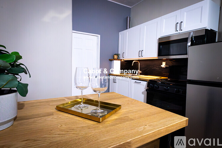 A kitchen with a wooden table and a tray with two glasses on it.